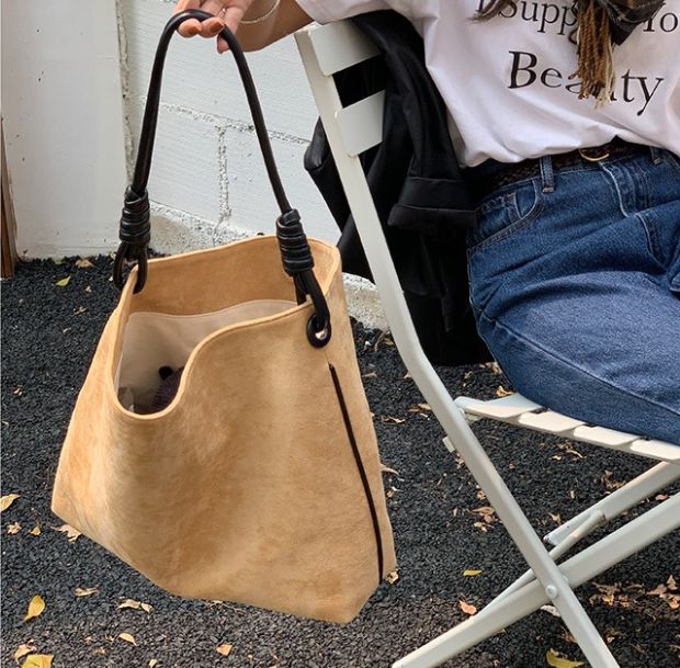 ノットハンドルベルベットトートバッグを持つ女性